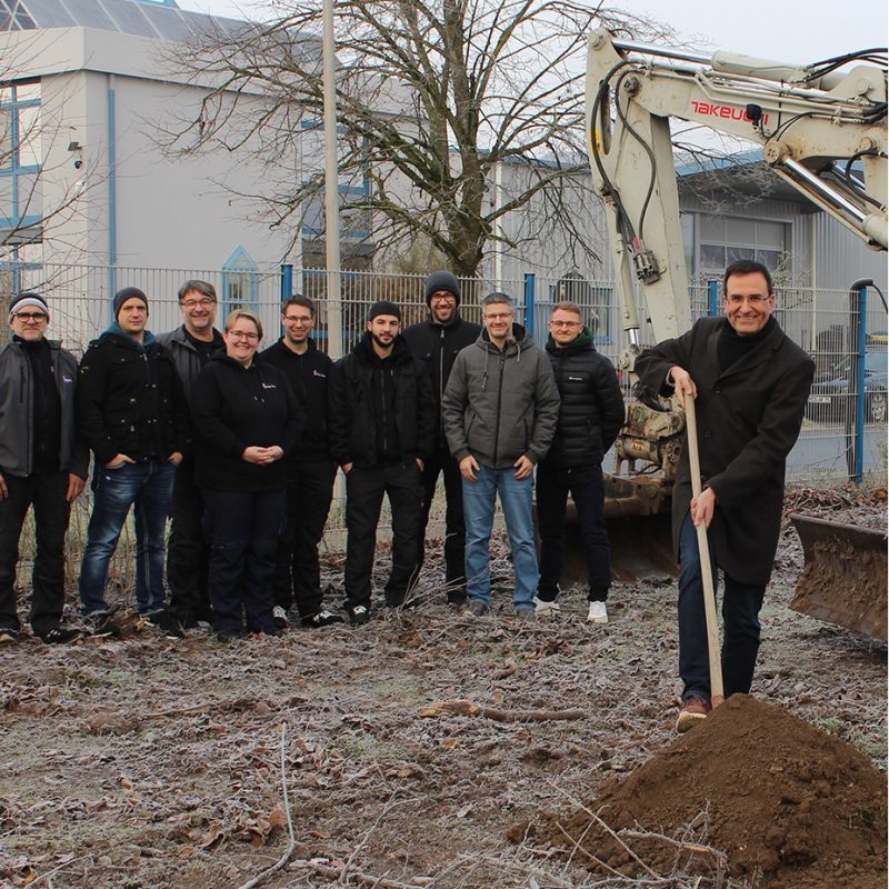 Alexander Dürsch, Geschäftsführer von Ergo-Tec it einem Teil des Ergo-Tec-Teams beim ersten Spatenstich für die neue Lagerhalle von Ergo-Tec.